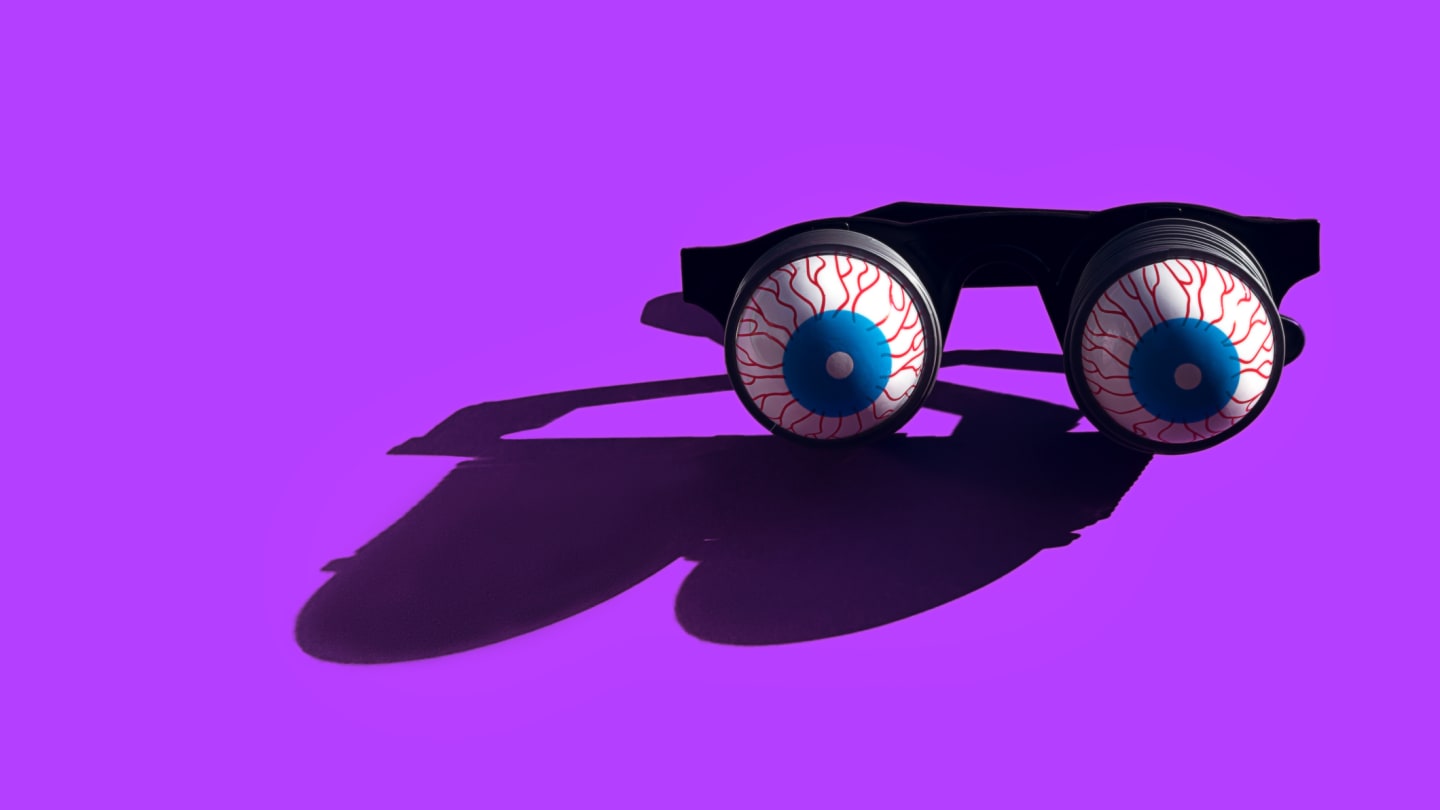 Black novelty glasses with realistic eyeball lenses on a vibrant purple background.