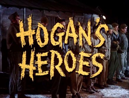 Title card for "Hogan's Heroes" TV show featuring cast in POW camp setting with bold yellow lettering.