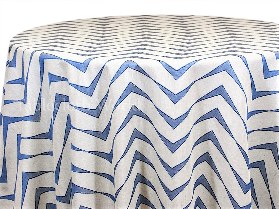 Blue and white chevron-patterned round tablecloth draped over a table, showcasing bold geometric design and fabric texture.