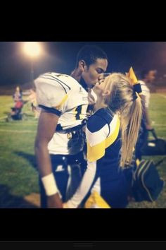 Football Player and Cheerleader Sharing a Romantic Moment on Field