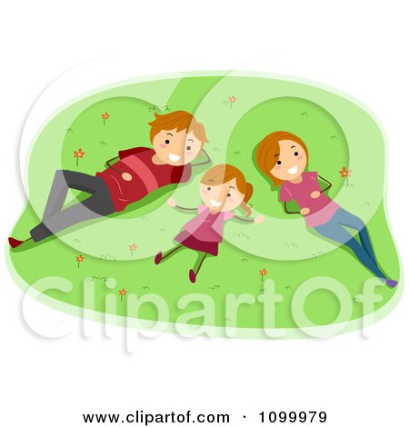 A smiling family of three-father, mother, and daughter-lying on a grassy field with flowers, enjoying outdoor relaxation.