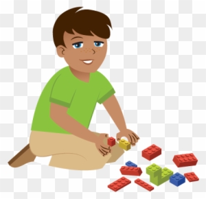 A smiling boy in a green shirt sits on the floor playing with colorful LEGO bricks.