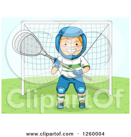 Young boy in lacrosse gear smiling while holding a stick in front of a goal on a grass field.