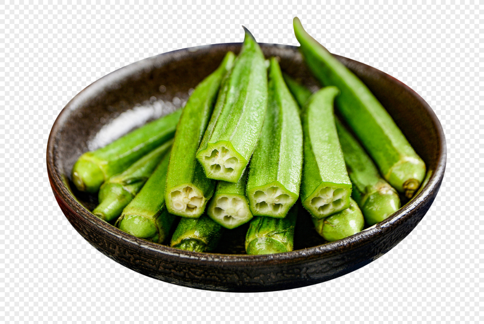 Fresh green okra pods in a rustic dark ceramic bowl, some sliced to reveal star-shaped cross-sections.