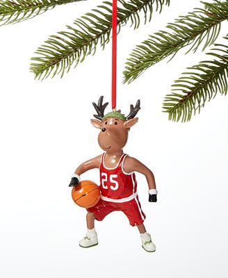Basketball-playing reindeer ornament in red jersey #25, hanging from a pine branch.