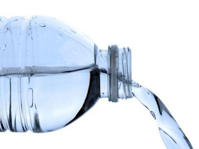 Clear plastic water bottle pouring fresh water against white background