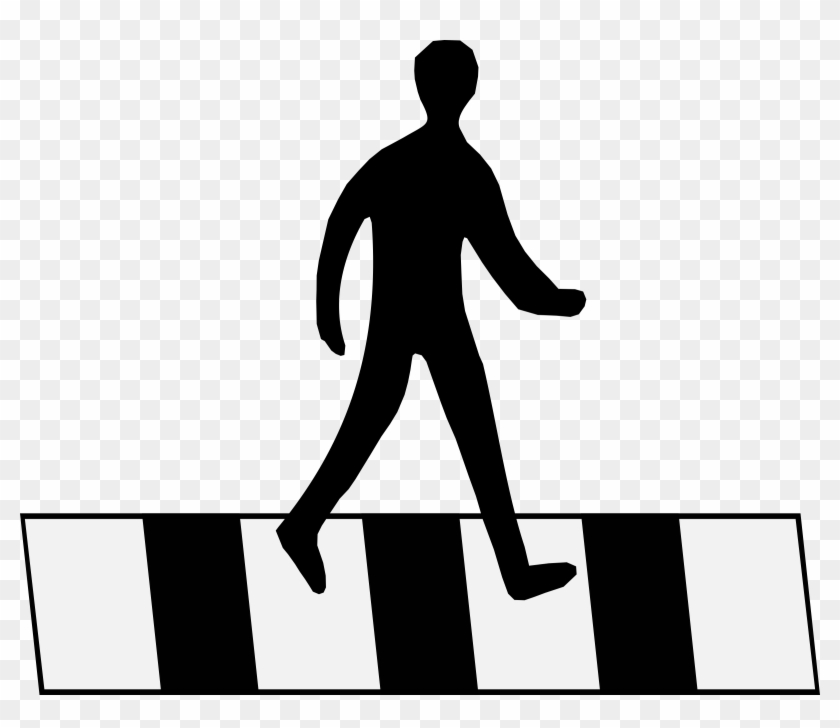 Silhouette of a person walking across a black-and-white striped crosswalk.