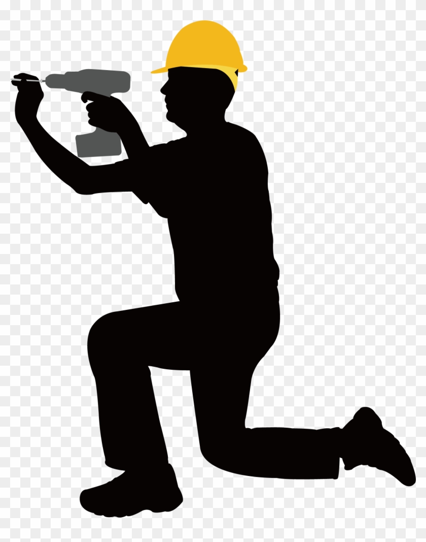 Silhouette of a construction worker in yellow hard hat kneeling while using a power drill.