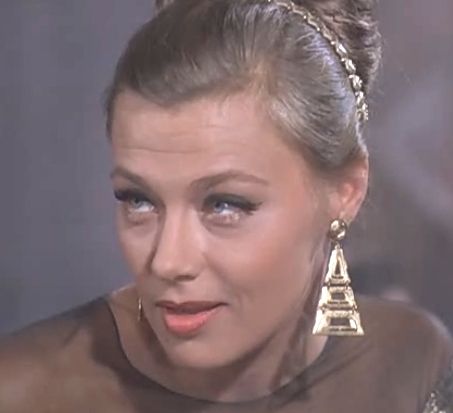 Classic portrait of a woman with elegant updo, gold Eiffel Tower earrings, and vintage makeup.