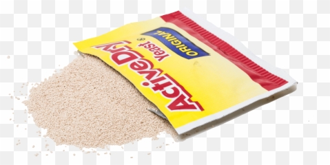 A yellow and red packet of Active Dry Yeast tipped over, spilling beige granular yeast onto a transparent background.
