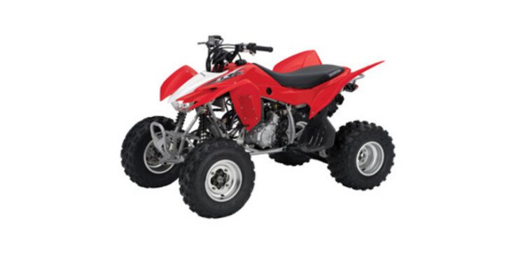 Red Honda TRX450R sport ATV with black seat, silver wheels, and aggressive off-road tires on white background.