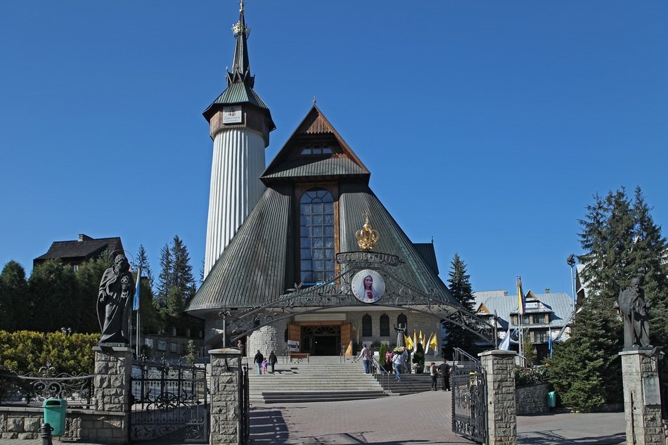 Sanctuary of Our Lady of Fatima in Zakopane, Poland, featuring its distinctive wooden architecture and spire under a clear blue sky.