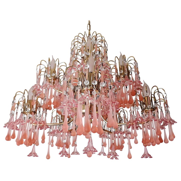 Elegant vintage pink Murano glass chandelier with gold frame and crystal accents, cascading teardrop elements.