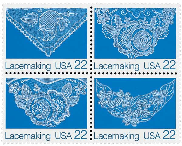 Four USPS 22-cent "Lacemaking USA" postage stamps featuring intricate white lace designs on blue background.