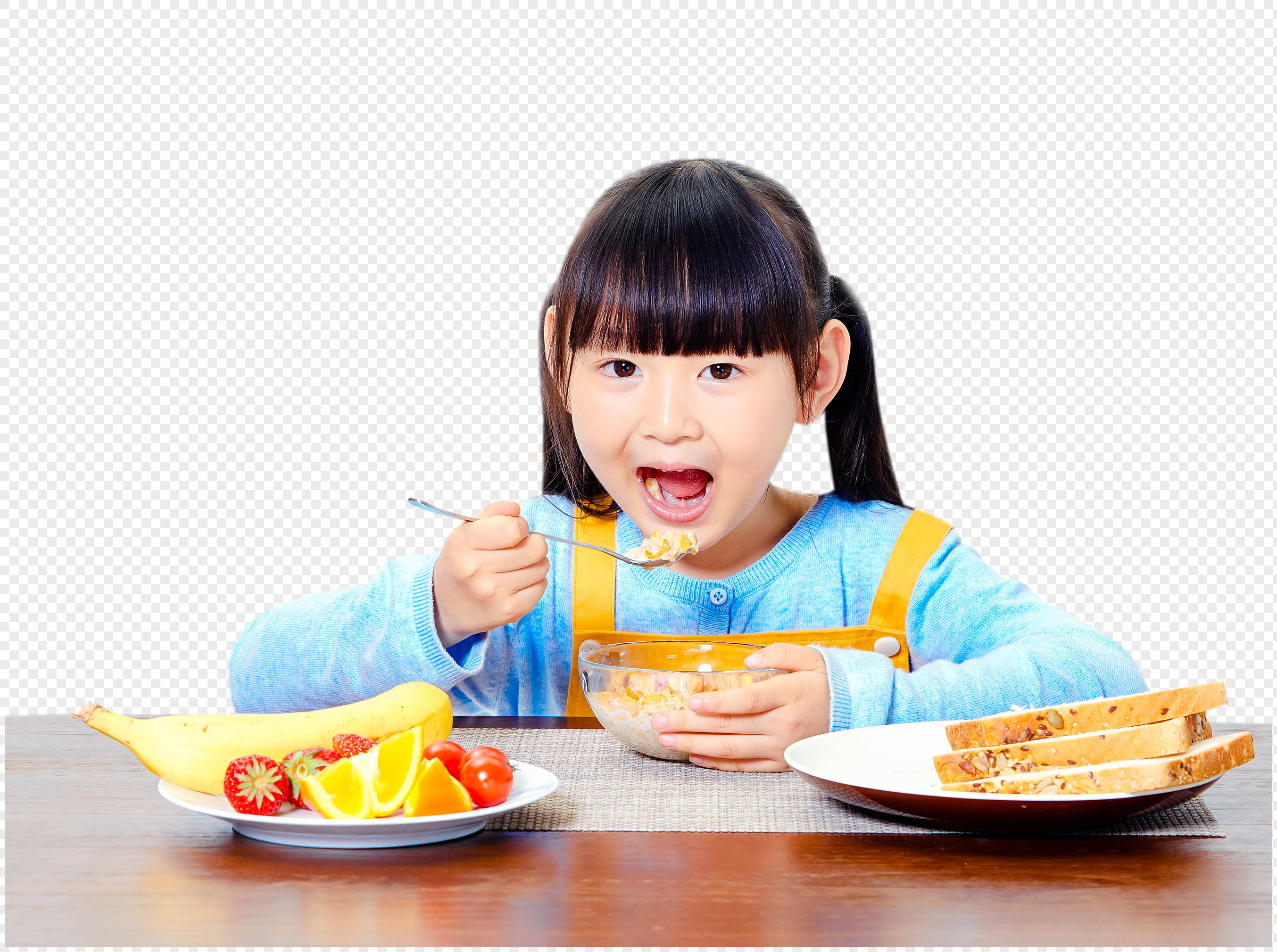 Happy young girl eating cereal with fruit and whole grain toast for a healthy breakfast.