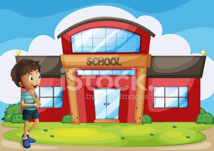 A smiling boy stands in front of a colorful red school building under a blue sky with clouds.