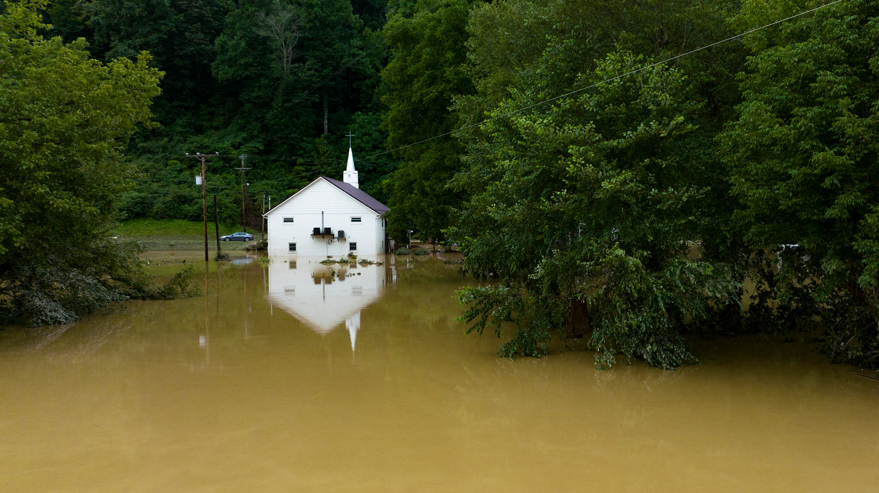 Flooded Rural Church Amidst Forested Landscape - Environmental Impact Photo