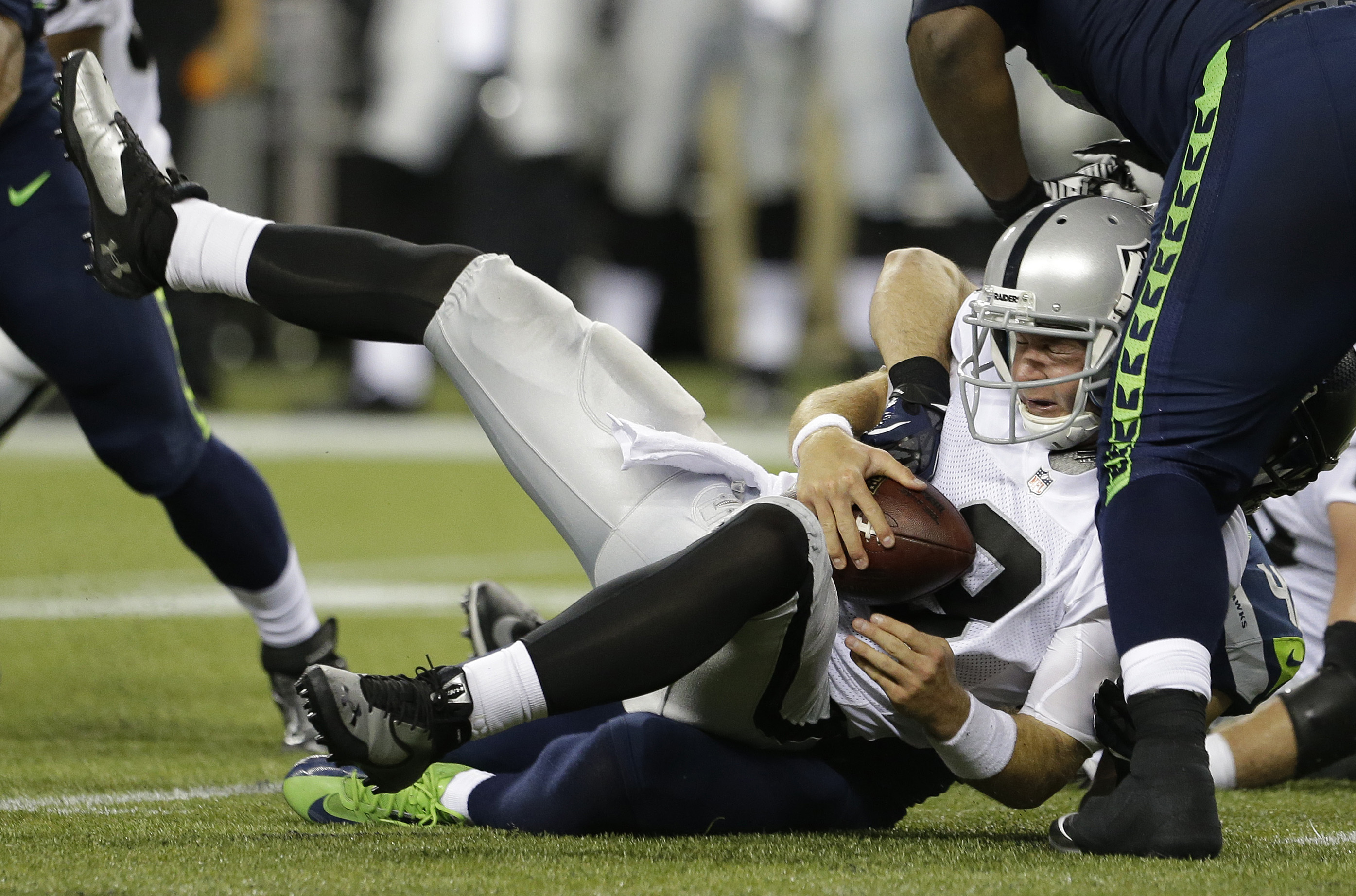 Raiders Quarterback Sacked by Seahawks Defense in Intense NFL Matchup