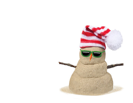 Sandy snowman wearing red-and-white striped Santa hat, green sunglasses, and carrot nose on white background.