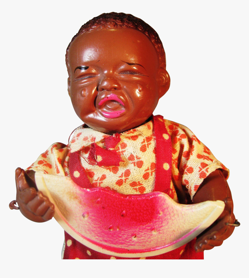 Vintage Black baby doll with glossy brown skin, wearing floral bib and red suspenders, holding a watermelon slice.