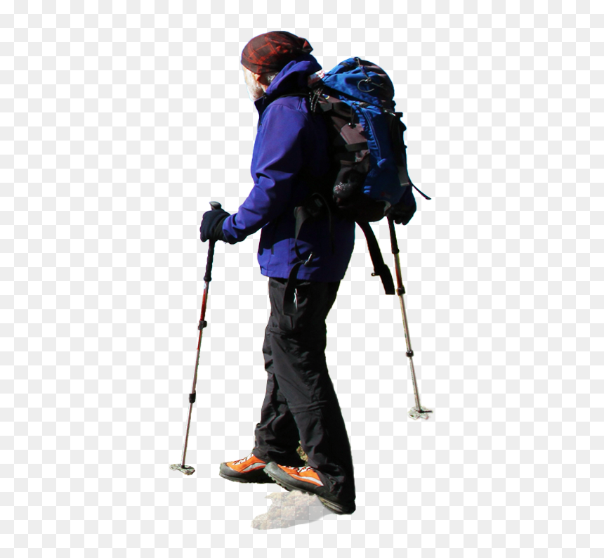 Hiker in blue jacket and orange boots with backpack and trekking poles, walking on snow-covered terrain.