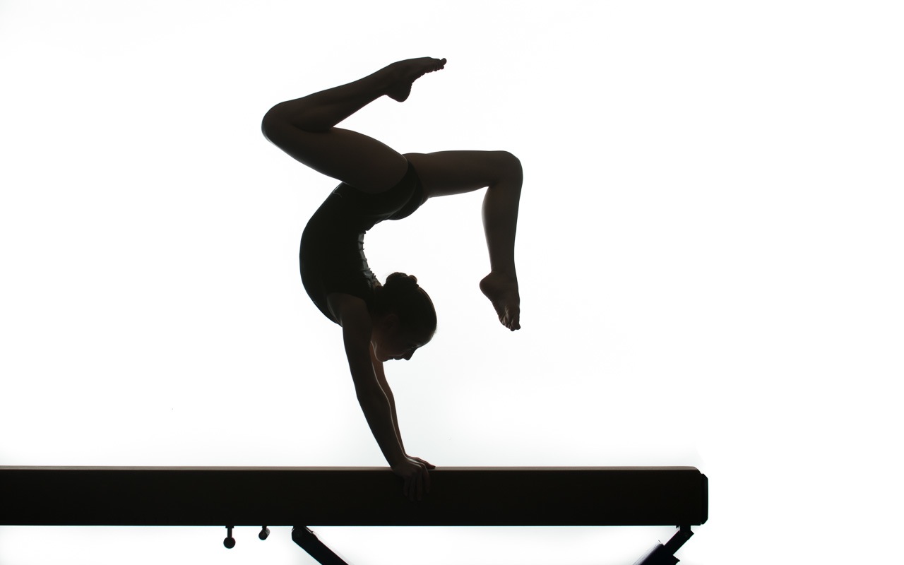 Gymnast Performing Backbend on Balance Beam - Silhouette Artistry