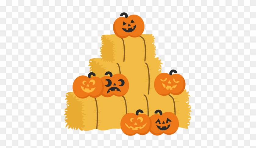 Stack of hay bales decorated with smiling jack-o'-lanterns for Halloween.