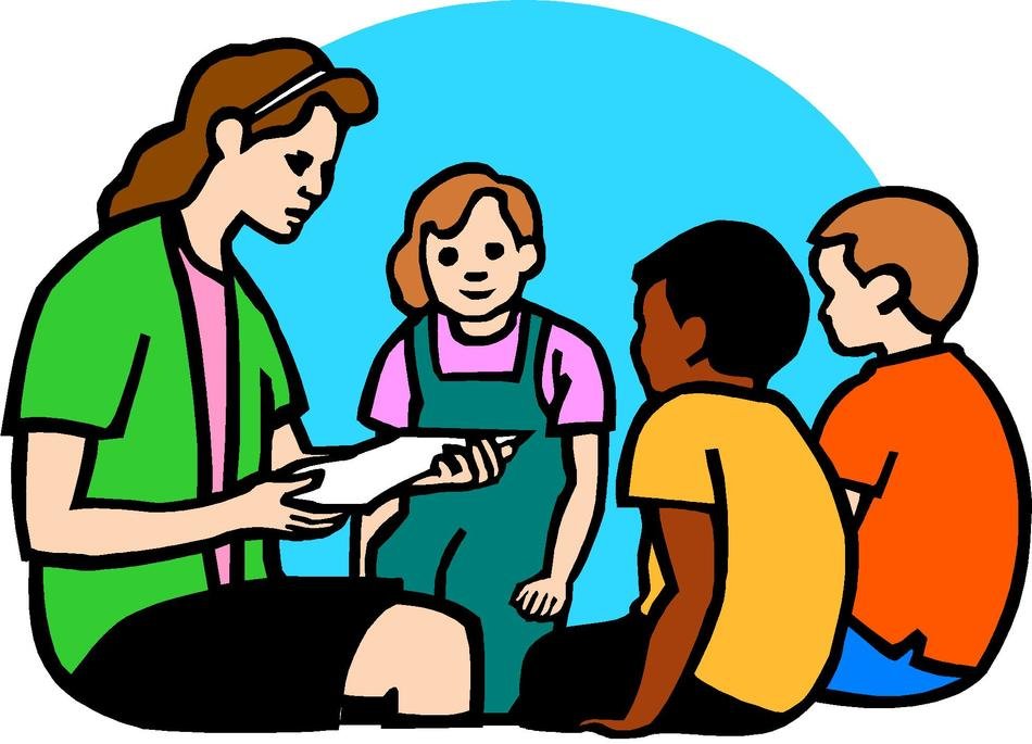 A teacher reads a paper to three diverse children seated on the floor in a classroom setting.