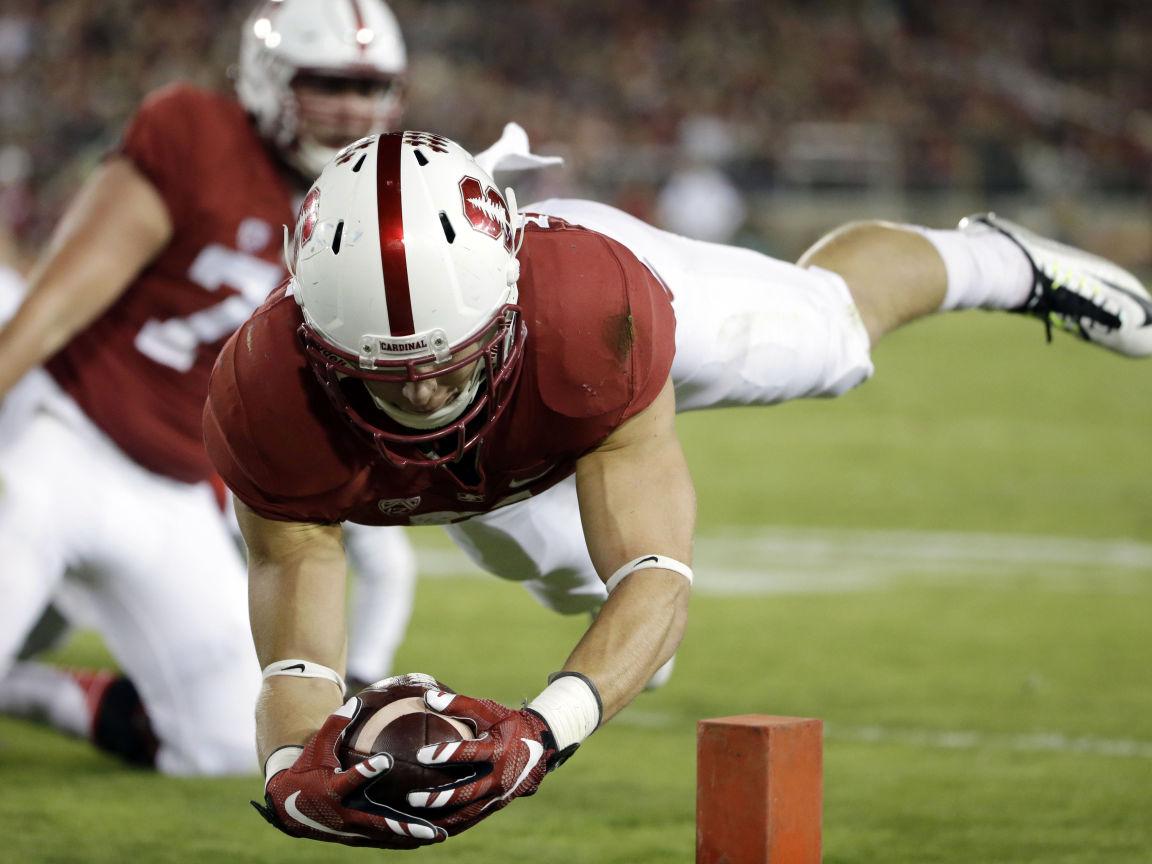 Stanford Cardinal football player diving for touchdown with ball secured near goal line, helmet and uniform visible.