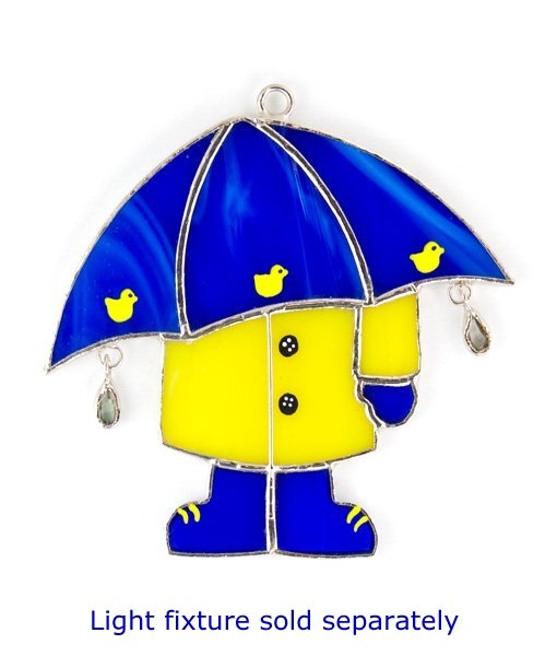 Stained glass ornament of a child in yellow raincoat and blue boots holding a blue umbrella with yellow ducks and hanging raindrops.