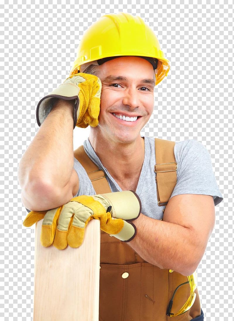 Smiling construction worker in yellow hard hat and gloves leaning on wooden plank.