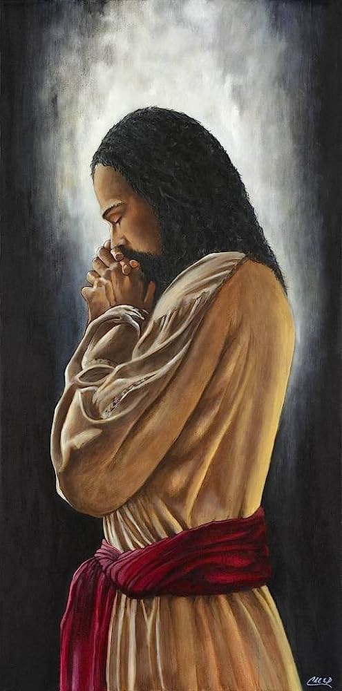 Jesus in prayer, hands clasped, eyes closed, wearing a beige robe with red sash, illuminated by divine light against dark background.