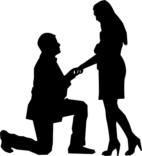 Silhouette of a man kneeling and proposing to a woman, holding her hand.