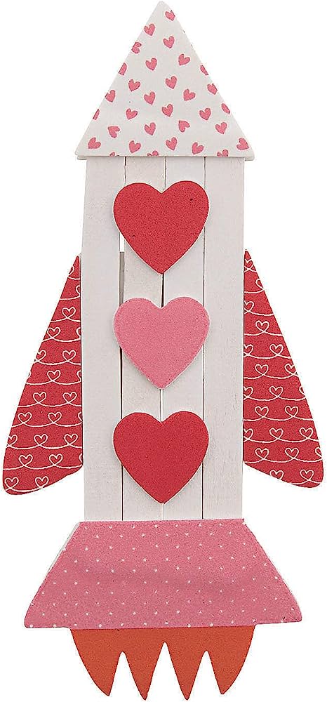 Handcrafted wooden rocket decorated with red and pink hearts, heart-patterned fins and nose cone, and polka-dot engine base.