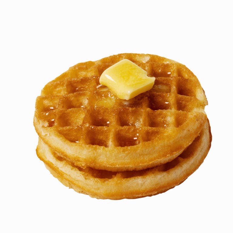 Golden Belgian waffle stack topped with melting butter and syrup, isolated on white background.