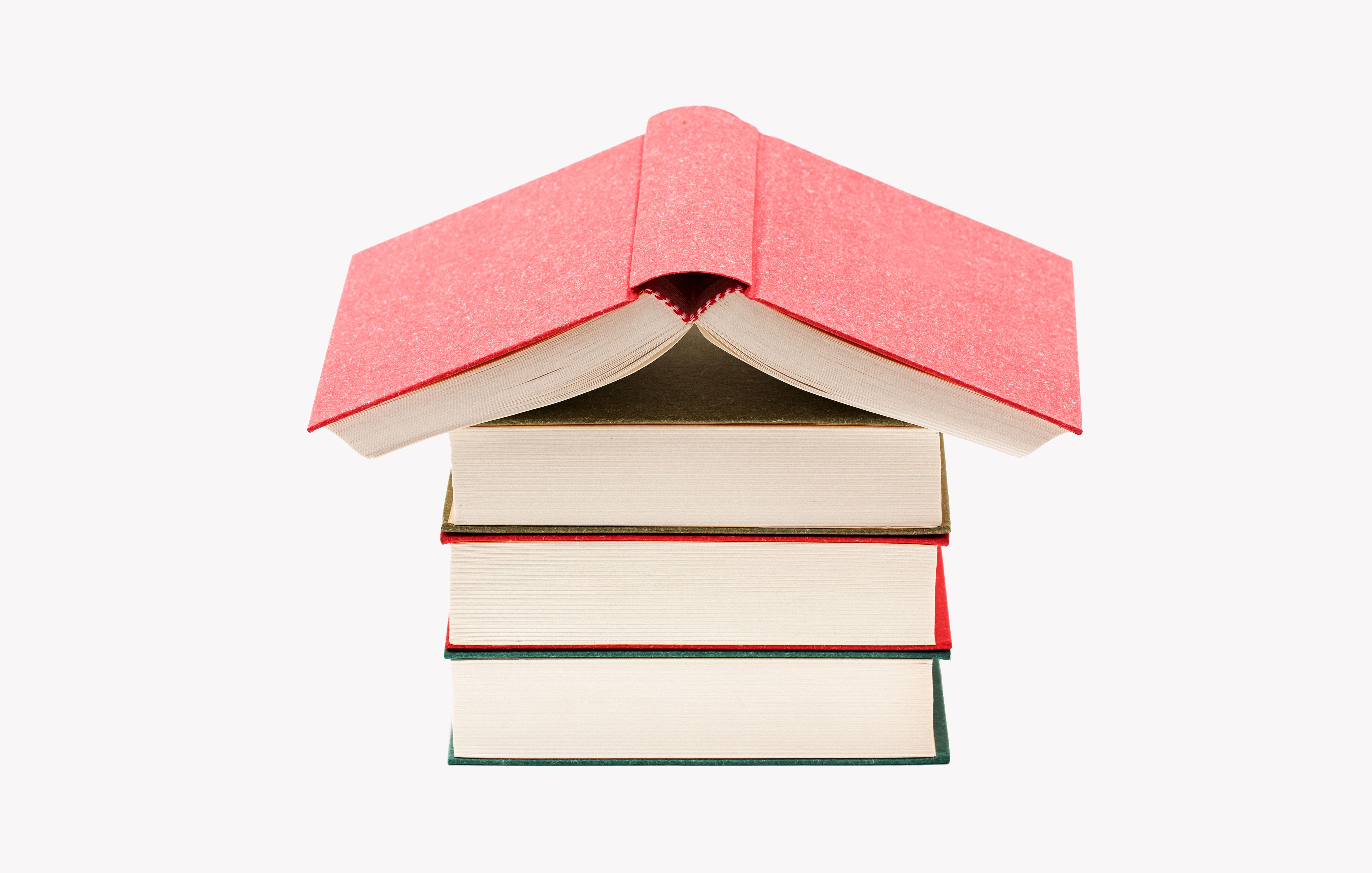 Stack of four books with top one open like a house roof, symbolizing knowledge as shelter or foundation.