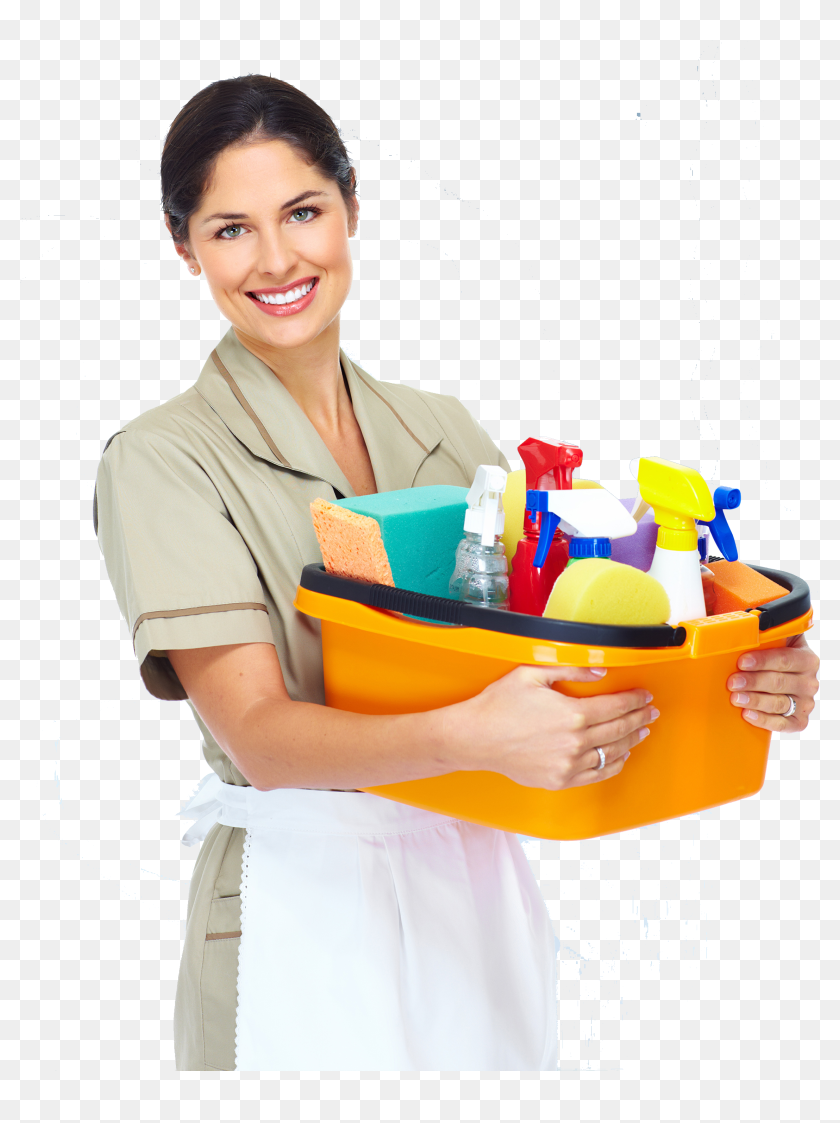Smiling professional cleaner holding an orange bucket filled with cleaning supplies including sprays, sponges, and cloths.