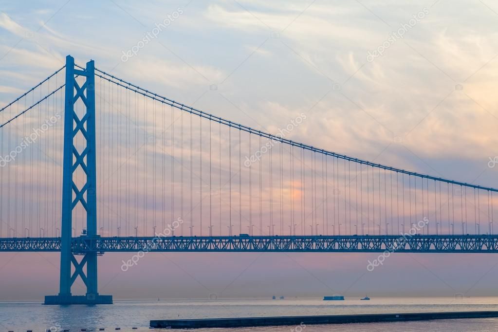 Akashi Kaikyō Bridge at dusk, Japan’s iconic blue suspension bridge spanning the Seto Inland Sea under soft pastel skies.