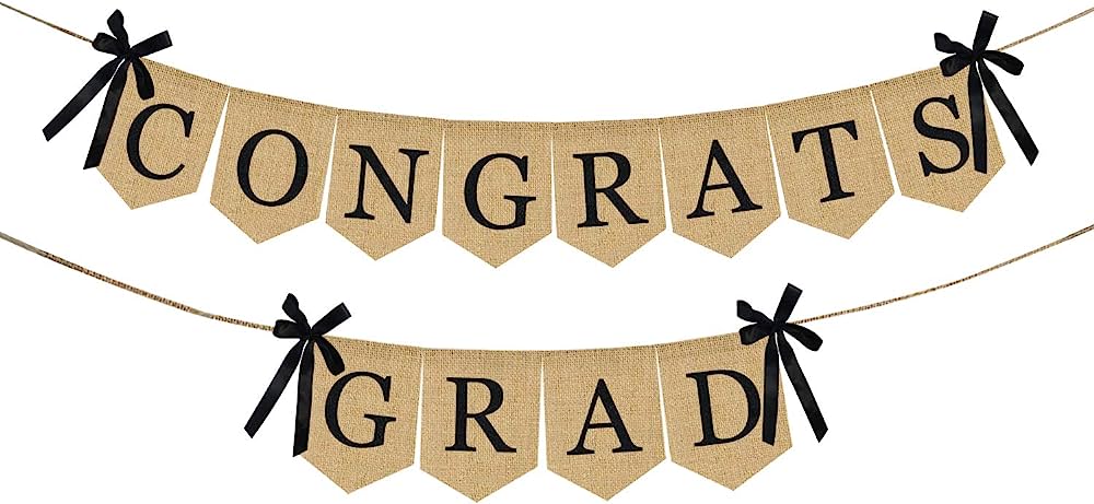 Rustic burlap banner with "CONGRATS GRAD" in black serif font, tied with black ribbons on twine strings.