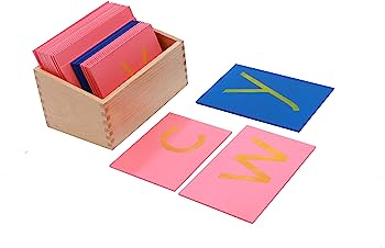Montessori sandpaper letter cards in pink and blue with wooden storage box, showing letters C, W, and Y.
