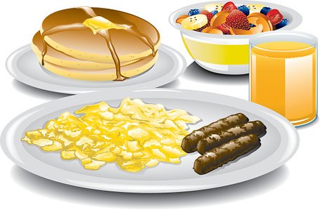 A hearty breakfast spread featuring pancakes with syrup, scrambled eggs, sausage links, fruit salad, and orange juice.