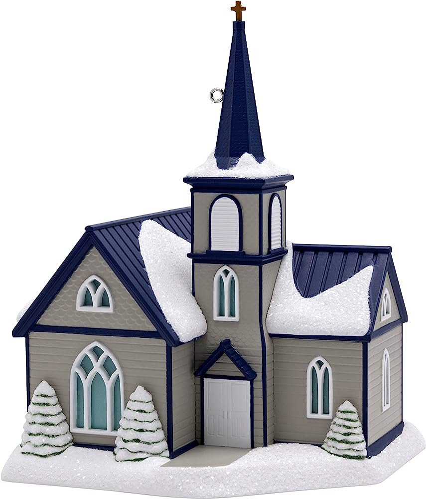 Snow-dusted miniature church ornament with blue steeple, arched windows, and evergreen trees.
