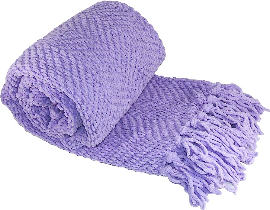 Soft lavender chunky knit blanket with tasseled fringe, rolled for display on white background.