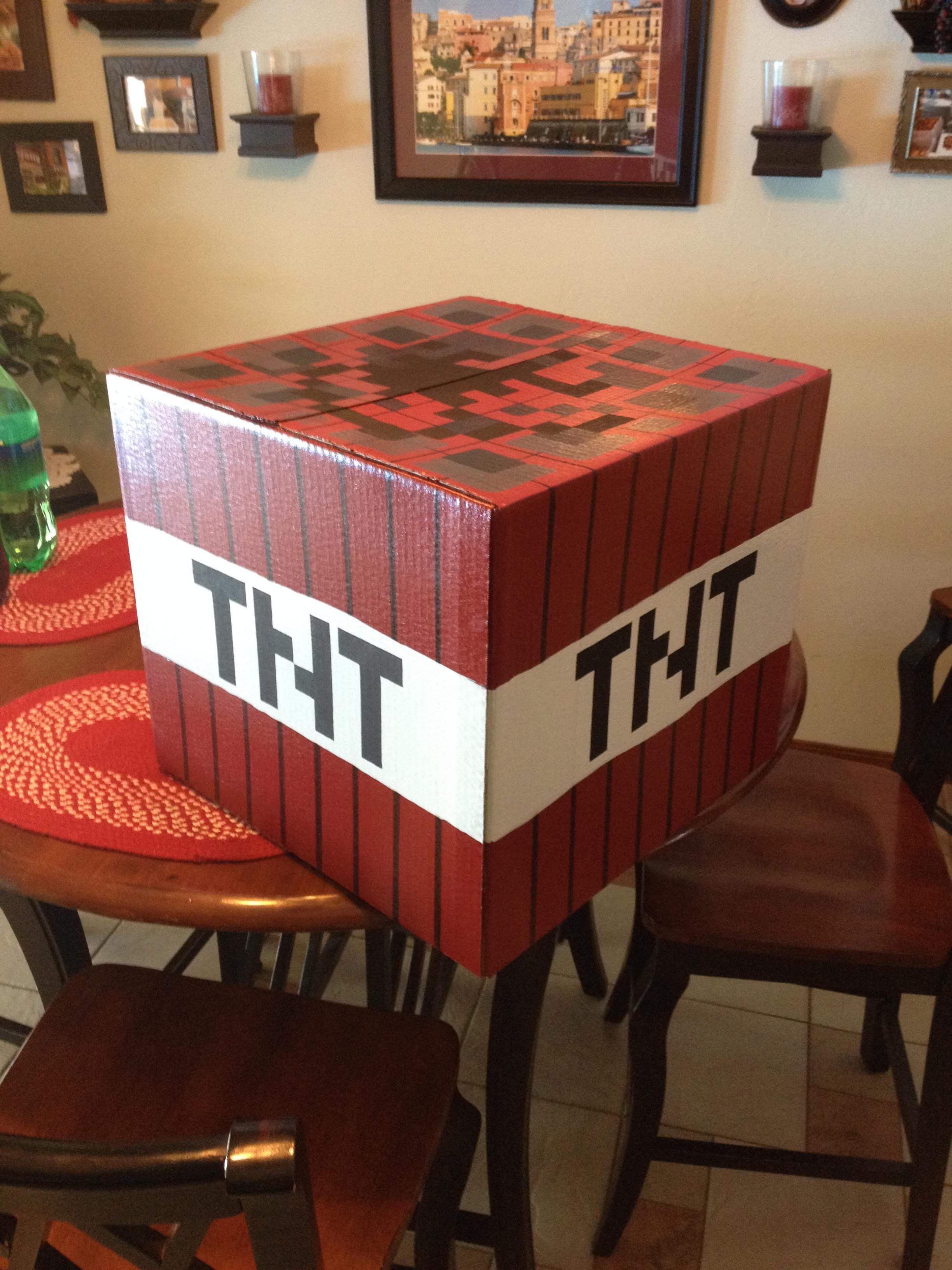 Handcrafted Minecraft-style TNT block box on a dining table, painted red with black stripes and bold "TNT" lettering.