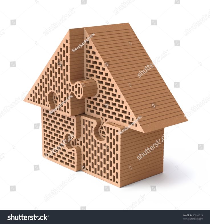 Wooden puzzle-piece house model with interlocking sections and brick-patterned texture, symbolizing home construction or real estate.