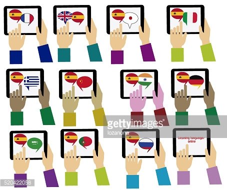 Multiple hands holding tablets displaying language flags and speech bubbles for multilingual communication and learning.