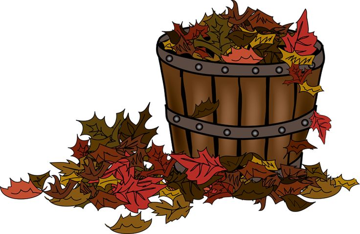 Wooden barrel overflowing with colorful autumn leaves, some scattered on the ground.