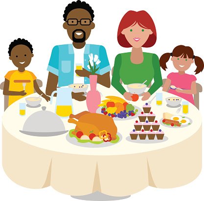 A diverse family of four shares a festive meal with roasted turkey, fruit, cupcakes, and drinks around a round table.