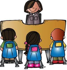 A teacher stands behind a large wooden desk, facing three seated students with colorful backpacks in a classroom setting.