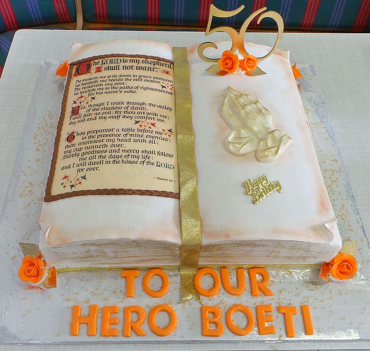 Bible-themed 50th birthday cake with Psalm 23, gold ribbon, praying hands, and "To Our Hero Boeti" in orange letters.